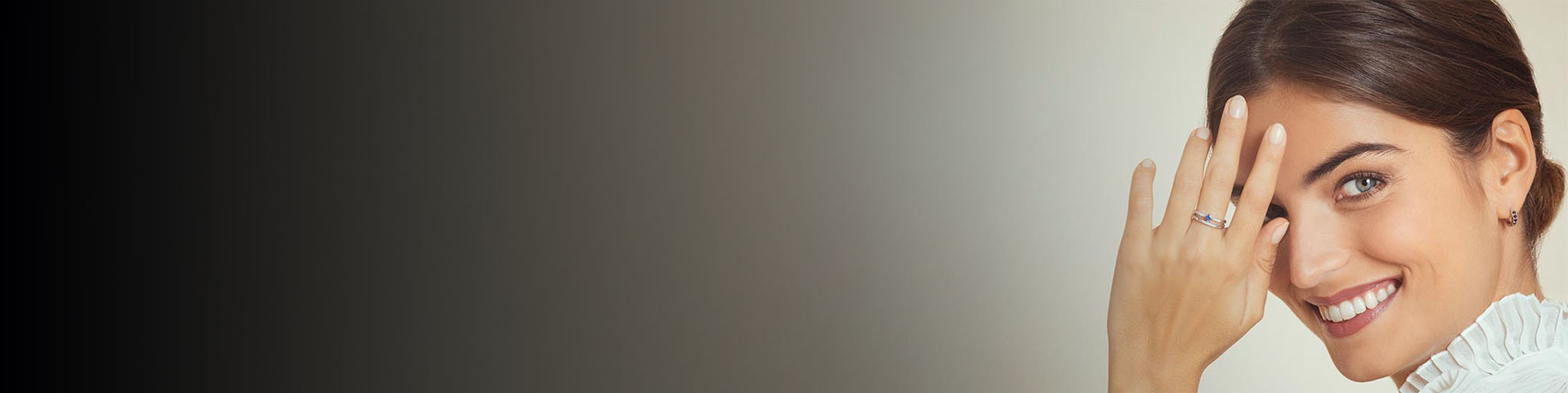 Anillo de zafiro oro blanco 18 quilates llevado por mujer sonriente, alianza joyería fina con gema azul