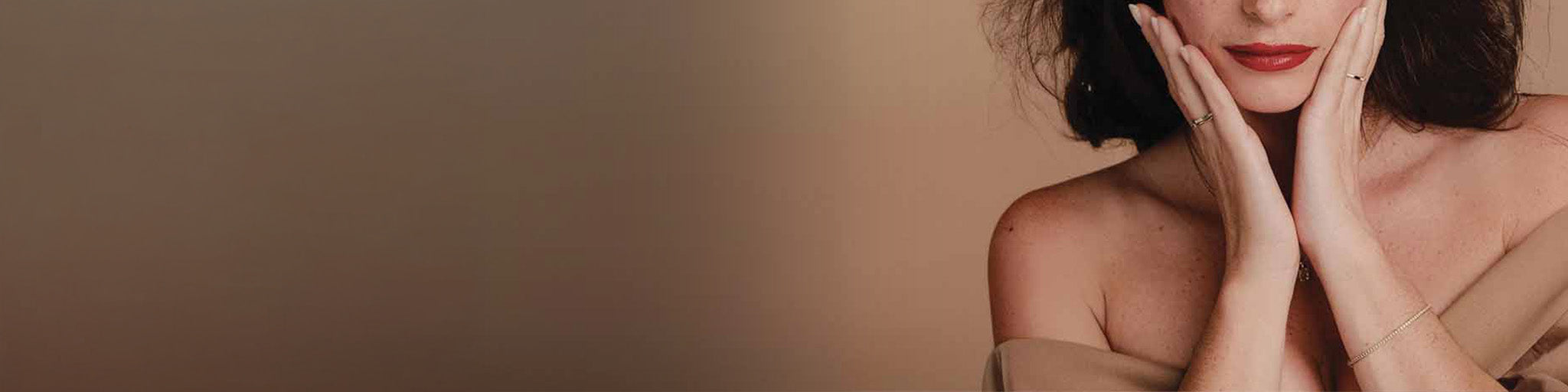 Pulseras tennis oro y diamantes portadas por mujer elegante labios rojos sobre fondo beige minimalista