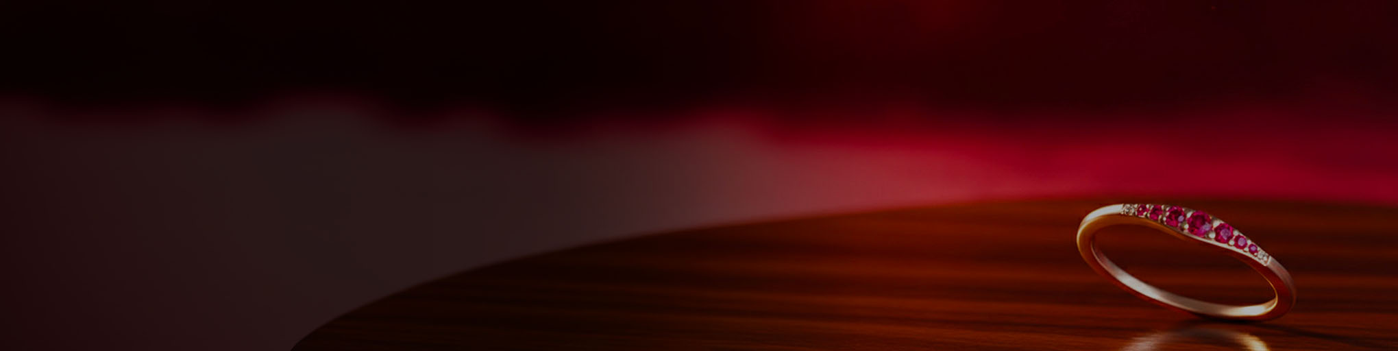 Alianza rubí oro rosa 18 quilates con pavé piedras preciosas rojas, joyería fina francesa sobre fondo degradado rojo