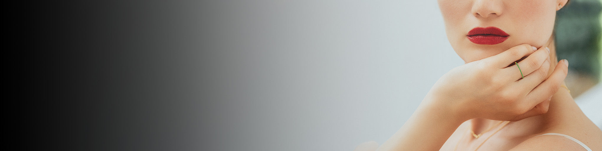 Anillo de esmeralda oro amarillo 18 quilates llevado por mujer con labios rojos, joyería fina elegante refinada