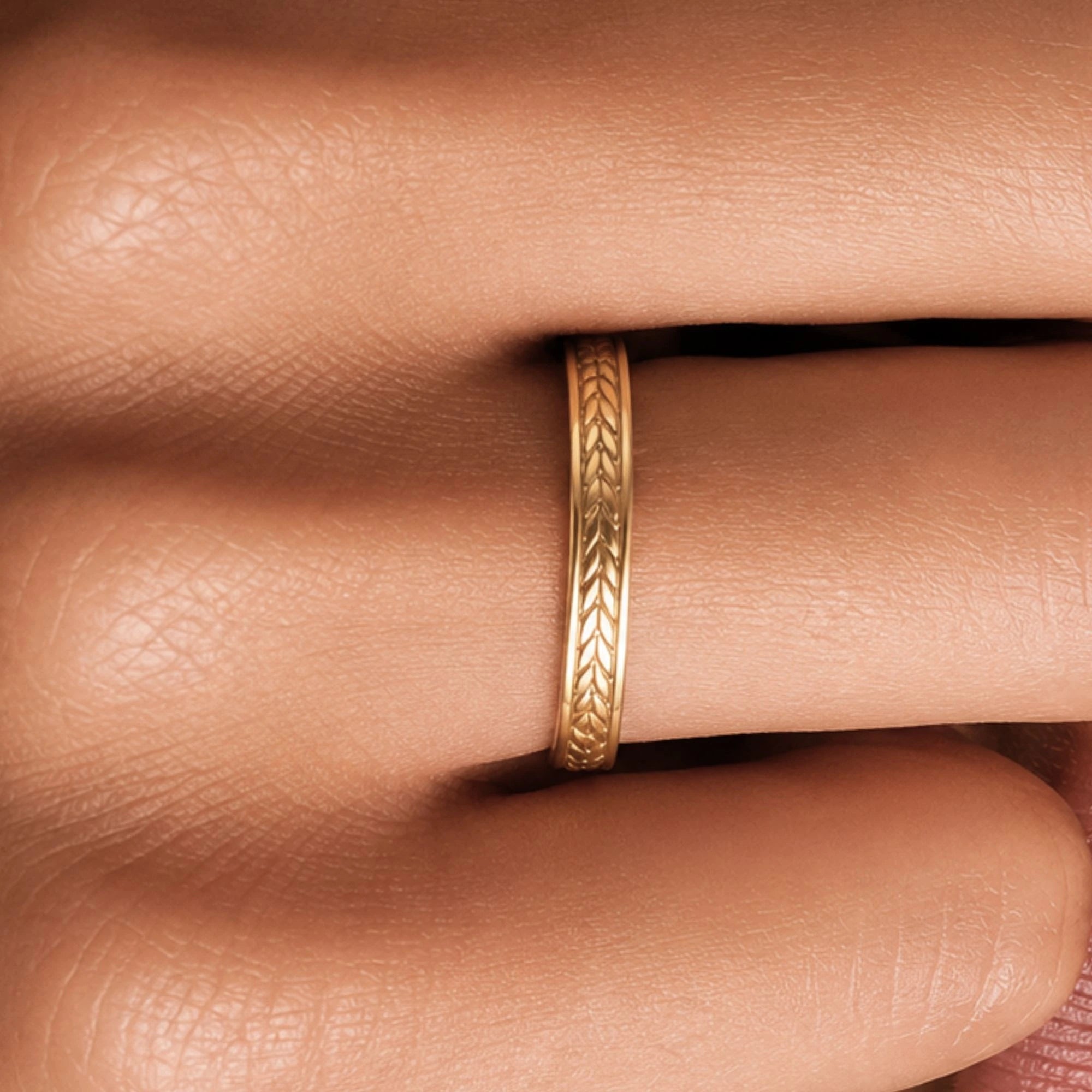 Alianza de boda en oro amarillo Kléos llevada en el dedo, detalle del grabado