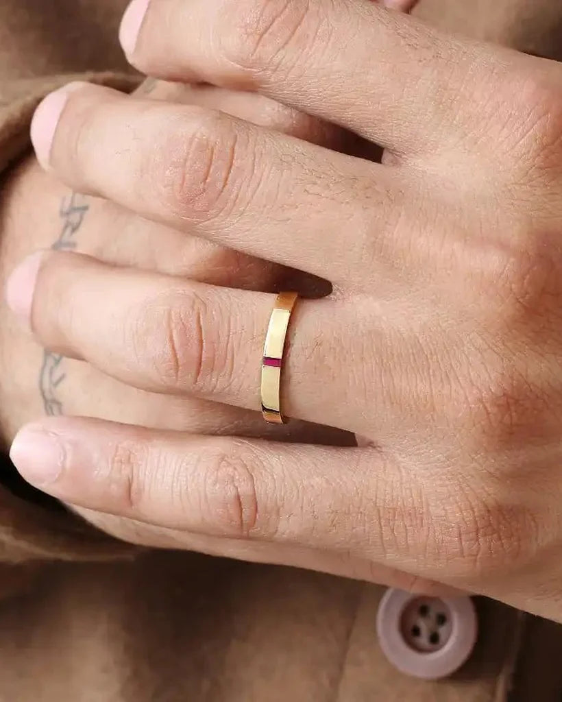 Bague de fiançailles homme Agni en or jaune 18 carats sertie d'un rubis baguette, portée à l'annulaire