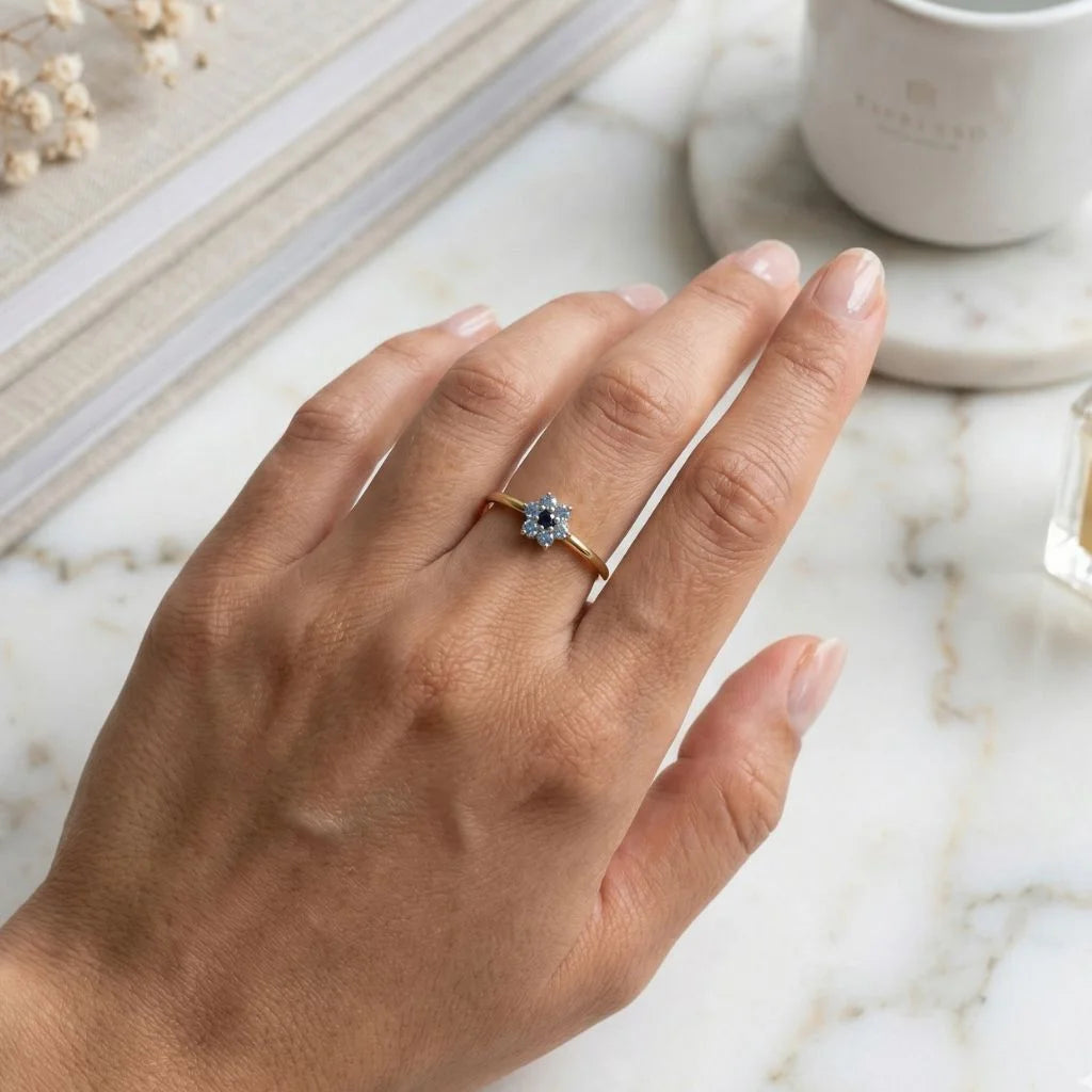 Anillo flor en oro amarillo de 18 quilates, degradado de zafiros azules, llevado en el anular, ambiente lifestyle
