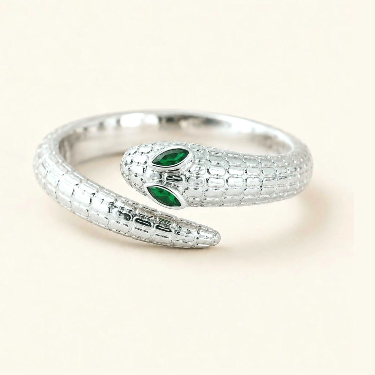 Anillo serpiente Méhen en oro blanco de 18k, cuerpo escamado y ojos de esmeralda marquesa