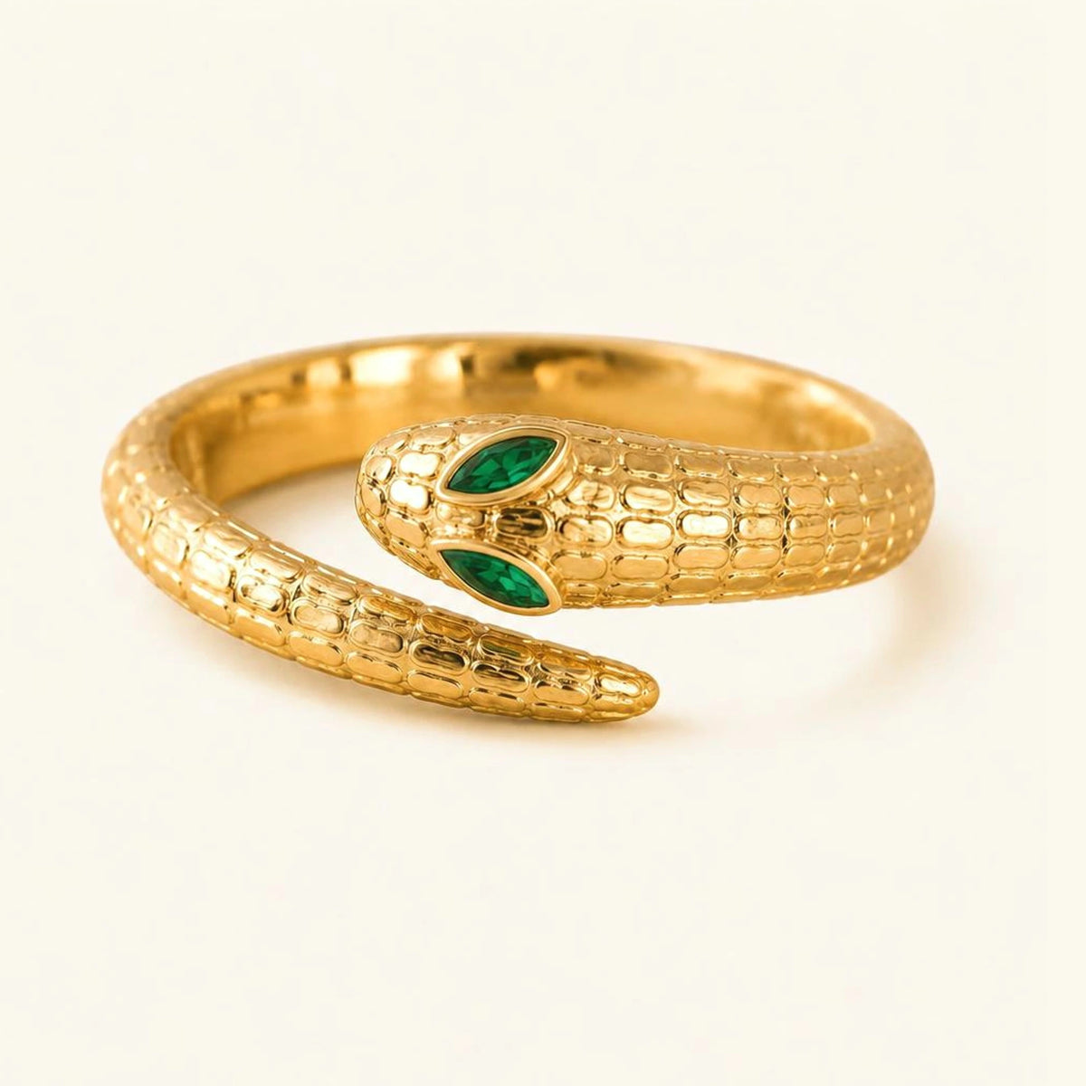 Anillo serpiente Méhen en oro amarillo de 18k, cuerpo escamado enroscado y dos esmeraldas marquesa como ojos