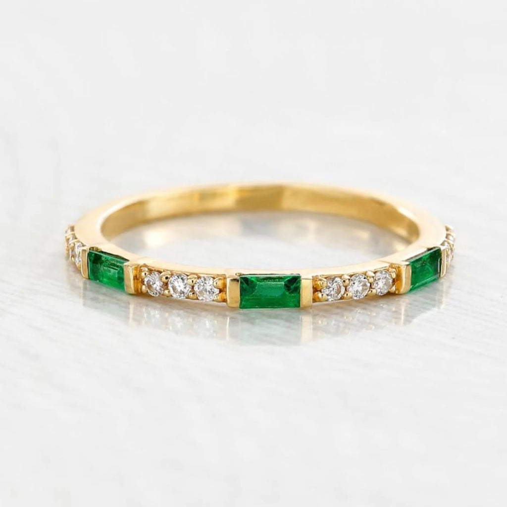 Anillo de oro amarillo y esmeralda sobre piel de subtono cálido, una armonía natural perfecta