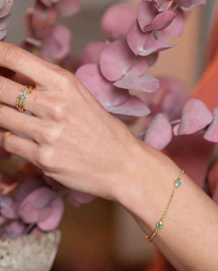 Pulsera Dhanya de esmeraldas y oro amarillo en la muñeca, idea de regalo para testigo de boda