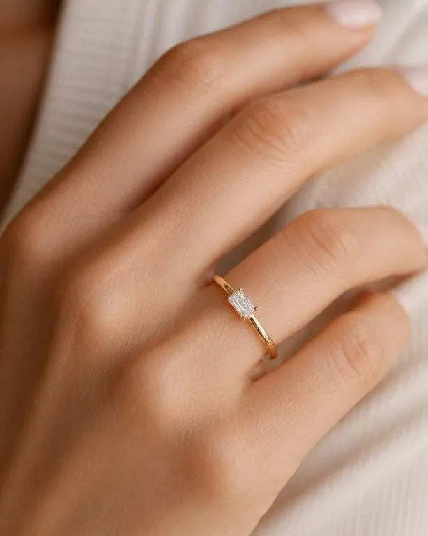 Bague solitaire diamant baguette portée au doigt, illustration du prix des diamants par carat