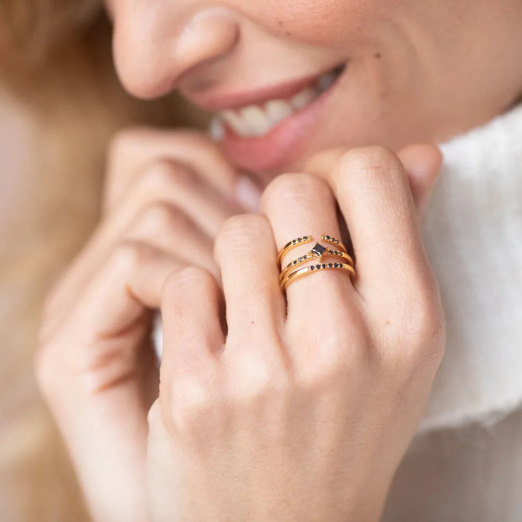 Anillos apilables Mayuri en oro amarillo y oro blanco engastados con diamantes negros, llevados juntos en el dedo