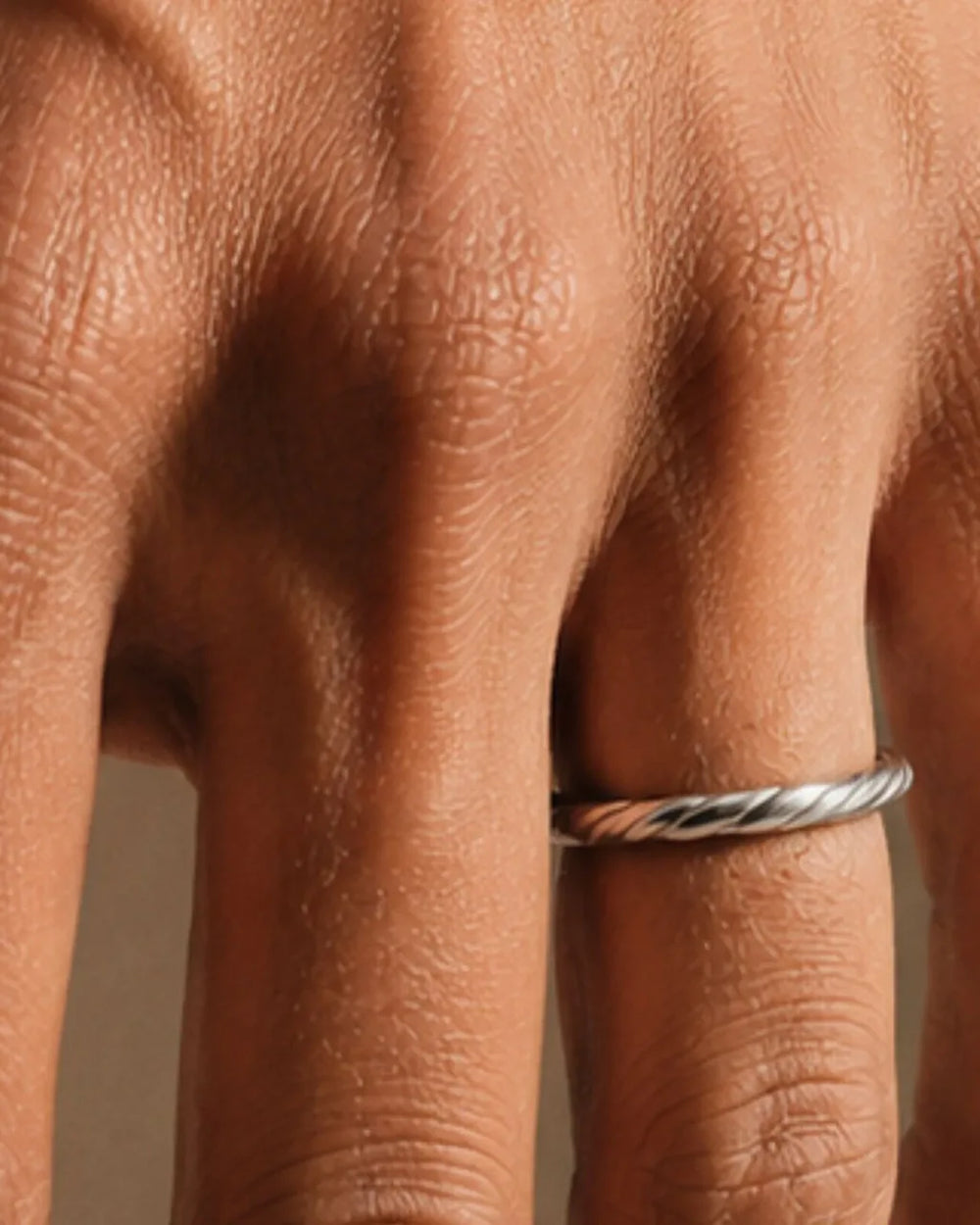 Alliance torsadée Vasuki en or blanc 18 carats portée au doigt, illustrant le guide de la taille de bague