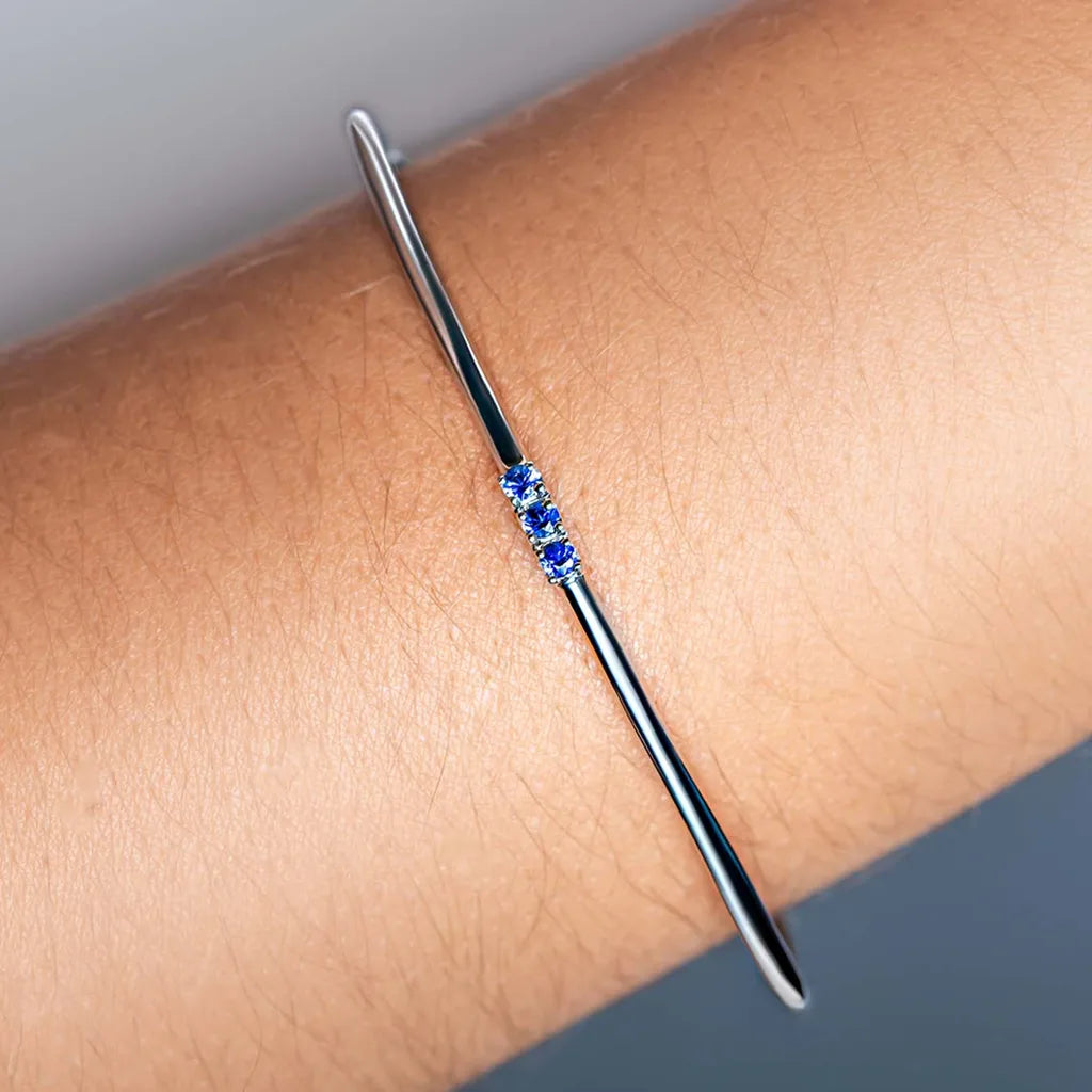Brazalete rigido Tina fino en Plata 925 engastado con tres Zafiros azules, llevado en la muñeca