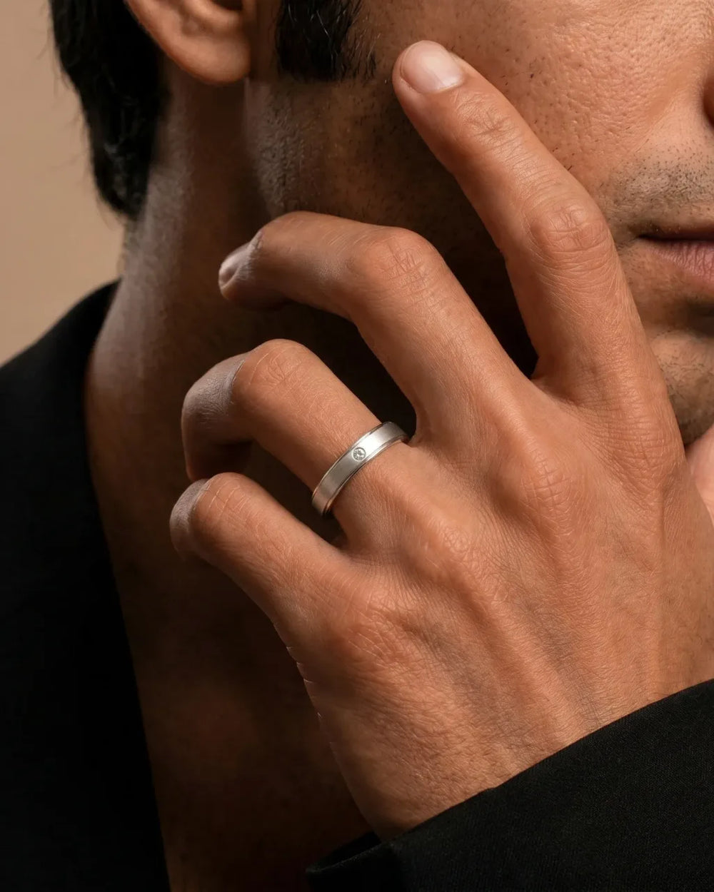 Alliance en platine sertie de diamants portée au doigt sur fond crème, entretien des bijoux Mayuri