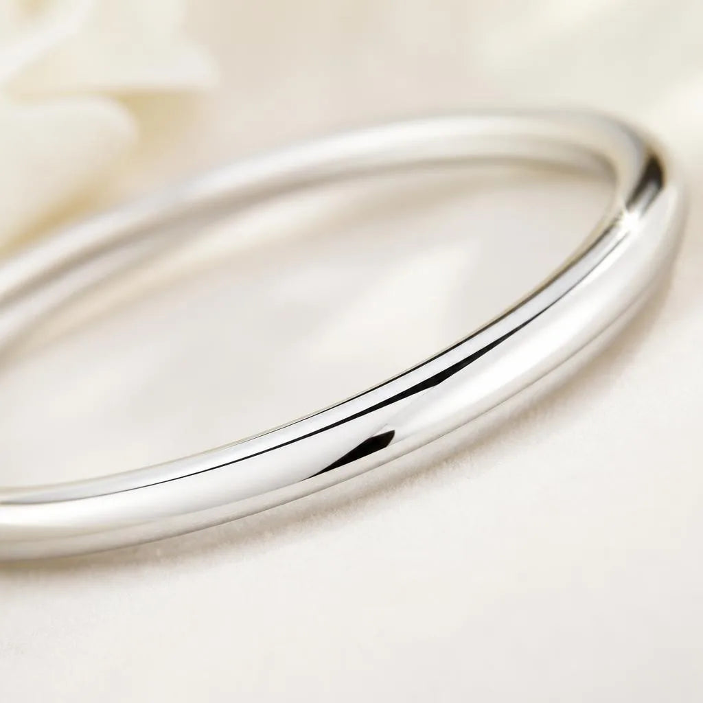 Primer plano de un brazalete rígido de plata 925 pulido, brillante tras la limpieza