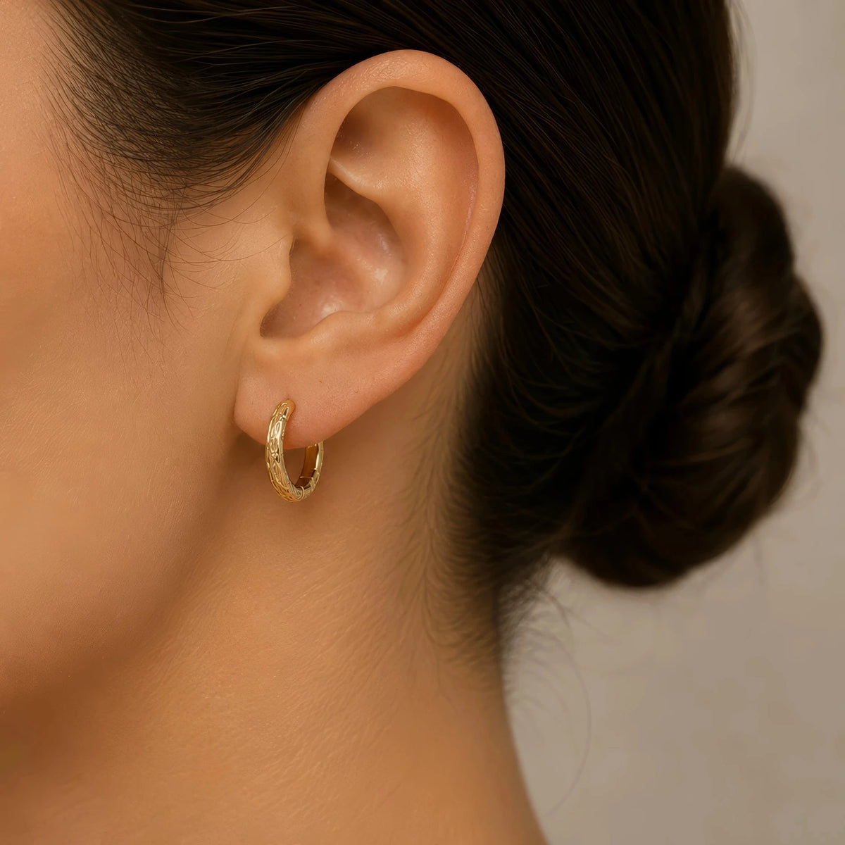 Aro Sobek en oro amarillo llevado en la oreja, aro con escamas de cocodrilo