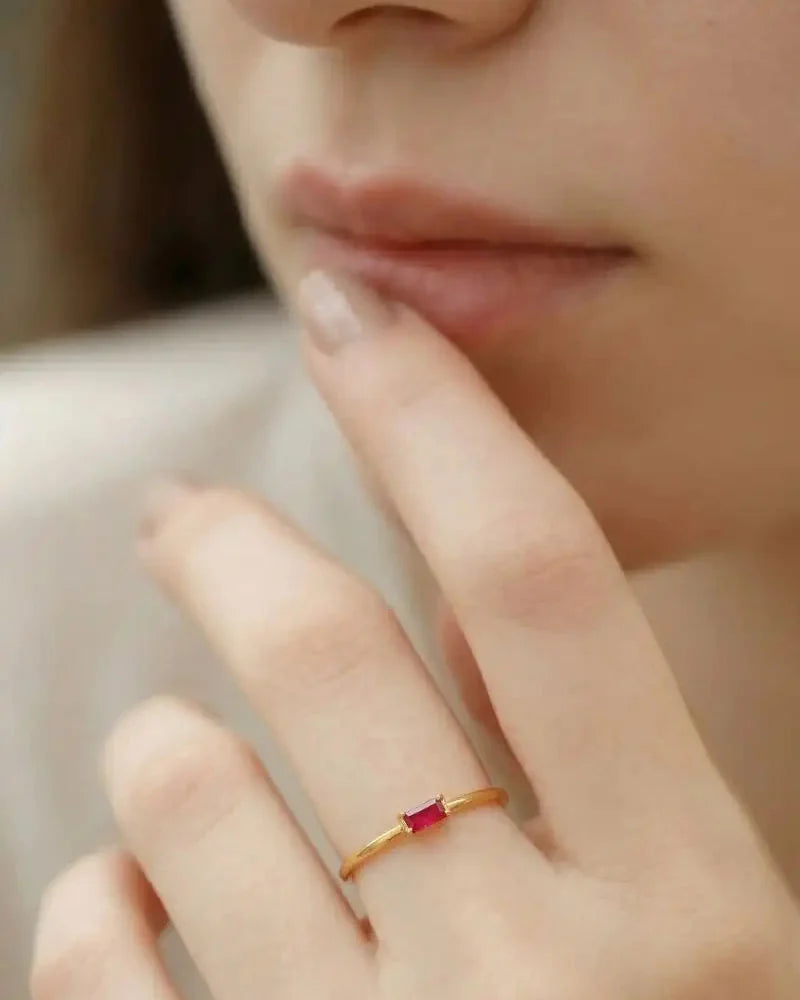 Bague de fiancailles rubis en or portee sur main feminine