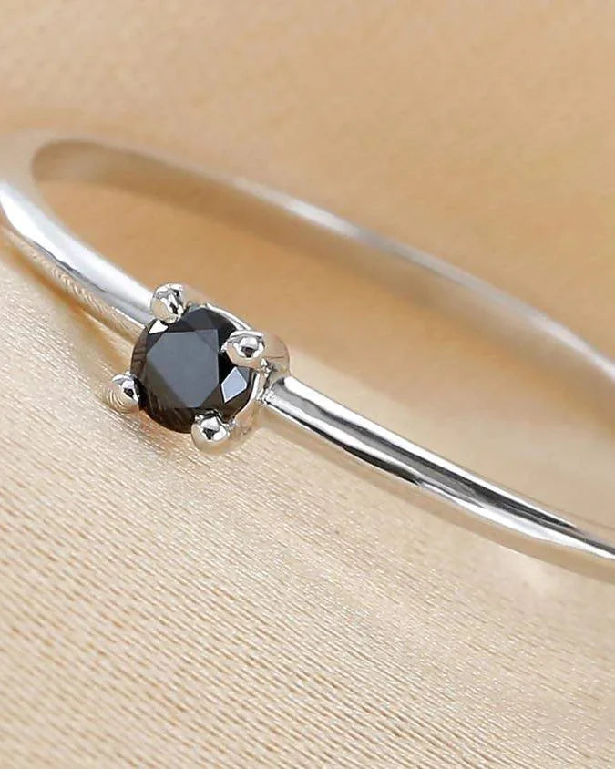 Bague Saral sertie d'un diamant noir, portée au doigt