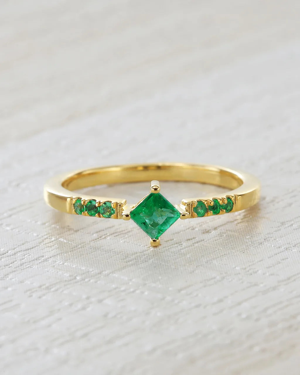 Anillo Kali en vermeil dorado engastado con esmeraldas naturales sobre fondo lino claro