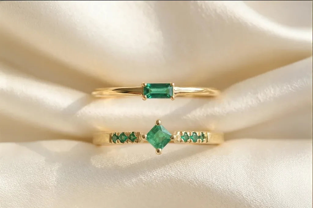 Dos anillos de compromiso de esmeralda en oro amarillo de 18 quilates por Mayuri, diseño solitario baguette y pavé