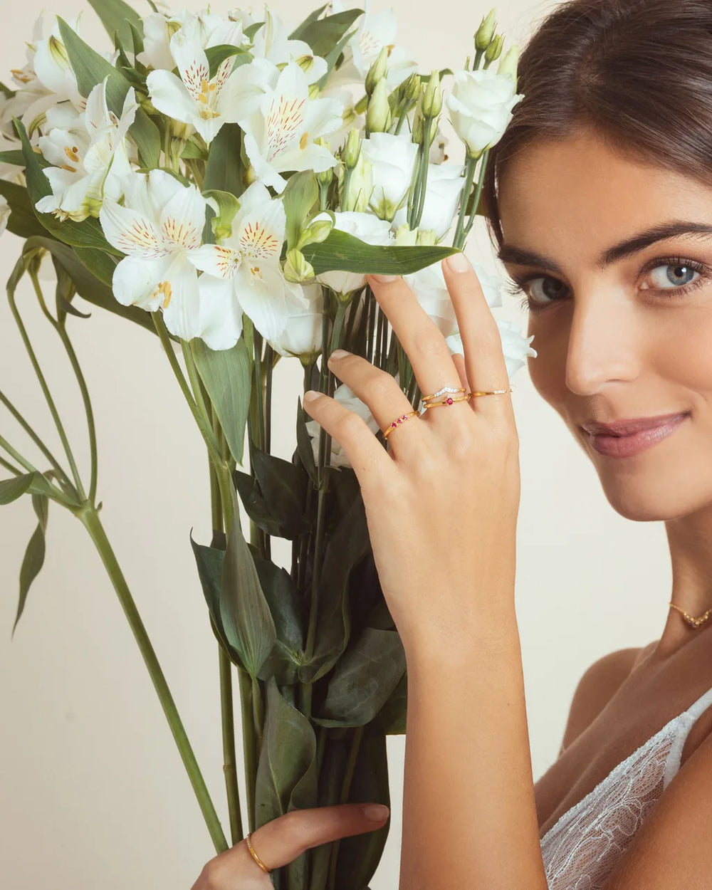 Bagues rubis or jaune 18 carats et collier Nadi portés par Mayuri, mise en valeur avec des fleurs blanches