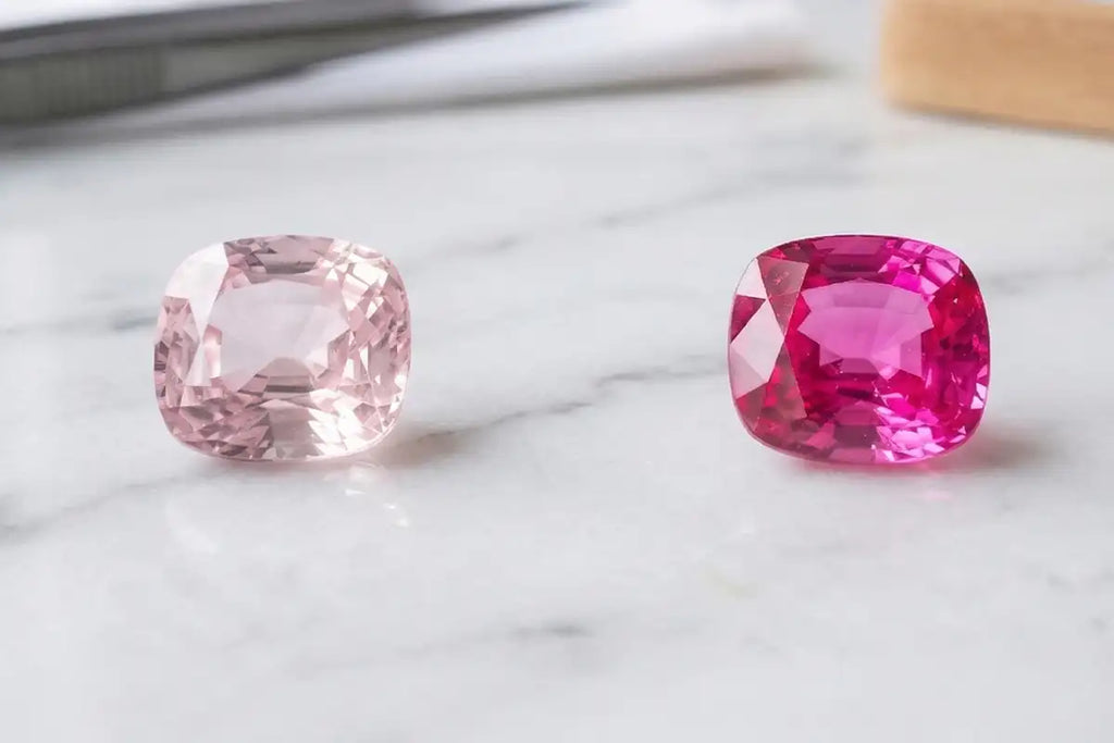 Comparativa entre un Zafiro rosa pálido y un Zafiro rosa intenso, sobre mármol blanco, que muestra el abanico de tonalidades