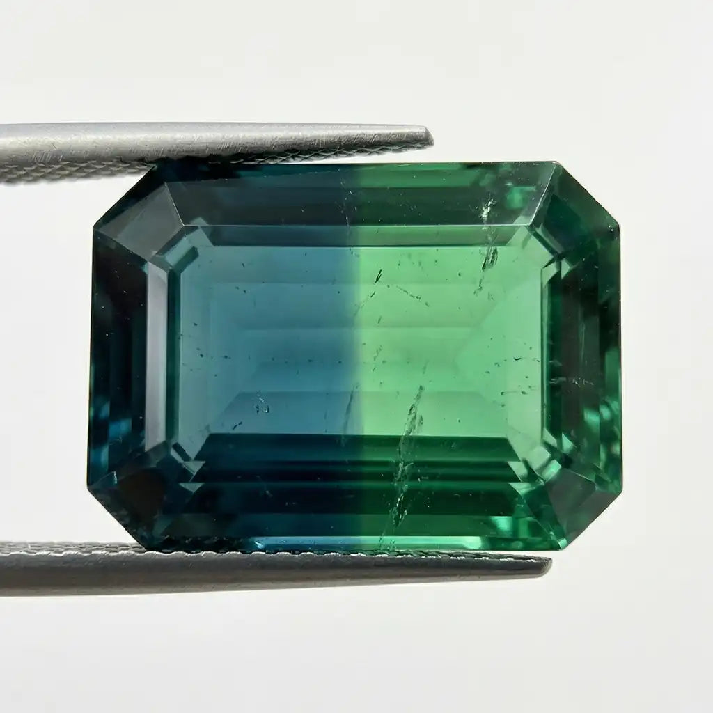 Zafiro teal bicolor que ilustra el color-zoning azul-verde sobre fondo blanco